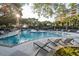 A resort-style pool with sun loungers and lush landscaping on a bright day at 4209 Ocean Club Dr, Isle of Palms, SC 29451