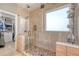 Glass-enclosed shower with decorative tile and pebble flooring, as well as a view of the walk-in closet at 422 Cabrill Dr, Charleston, SC 29414