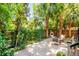 A beautifully landscaped backyard with a seating area and brick fireplace under the shade of palm trees at 50 South St, Charleston, SC 29403