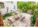 Charming outdoor patio area with lounge seating and wood-burning fireplace with lush tropical landscaping at 50 South St, Charleston, SC 29403