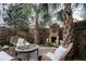 Private backyard retreat with a brick fireplace, mature trees, and comfortable seating area at 50 South St, Charleston, SC 29403