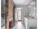 Bathroom boasts a modern vanity with dual sinks, a glass-enclosed shower, and a rustic exposed brick wall at 50 South St, Charleston, SC 29403