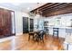 Dining area featuring hardwood floors, exposed beams, modern lighting, and a view into the adjacent kitchen at 50 South St, Charleston, SC 29403