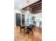 Dining area features hardwood floors, exposed beams, a modern light fixture, and a view into the kitchen at 50 South St, Charleston, SC 29403