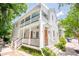 Inviting two-story home featuring a double porch, white siding, manicured landscaping, and natural light at 50 South St, Charleston, SC 29403