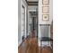 Hallway featuring hardwood floors, decorative wall art, and a view through doorways, accented by a stylish chair at 50 South St, Charleston, SC 29403