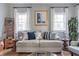 Cozy living room features a comfortable couch with stylish pillows, flanked by bright windows and charming decor at 50 South St, Charleston, SC 29403