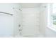 Bathroom featuring bathtub with white tile surround, shower head and window letting in natural light at 5042 Thornton Dr, Summerville, SC 29485
