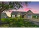 Charming single-story home featuring a well-manicured lawn and inviting curb appeal at sunset at 5042 Thornton Dr, Summerville, SC 29485