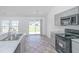 Modern kitchen with stainless steel appliances and breakfast bar, flowing into the dining area and backyard at 5042 Thornton Dr, Summerville, SC 29485