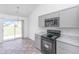 Bright kitchen with a view to the backyard, featuring stainless steel appliances and gray cabinets at 5042 Thornton Dr, Summerville, SC 29485
