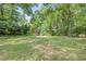 Large, well-maintained backyard featuring lush green grass, mature trees, and a cozy seating area at 5043 Victoria Ave, North Charleston, SC 29405