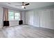 Bright bedroom with a ceiling fan, light gray wood flooring, and a large window for natural light at 5043 Victoria Ave, North Charleston, SC 29405