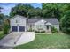 Charming home featuring a well-manicured lawn, an attached two-car garage, and tasteful exterior shutters at 5043 Victoria Ave, North Charleston, SC 29405