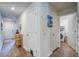 Bright hallway with wood-look flooring, white doors, and decor; leads to laundry room and front door at 510 Shady Maple St, Moncks Corner, SC 29461