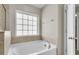 A bathtub with tile detail and a large window for natural lighting at 5138 Preserve Blvd, Ladson, SC 29456