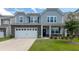 Charming two-story home featuring gray siding, stone accents, and a well-manicured lawn at 5138 Preserve Blvd, Ladson, SC 29456