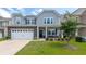 Beautiful two-story home with a stone facade, manicured lawn, and a two-car garage at 5138 Preserve Blvd, Ladson, SC 29456