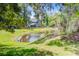 Scenic backyard with a tranquil pond surrounded by lush greenery and mature trees at 5433 Falling Tide, North Charleston, SC 29420
