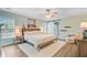 Comfortable main bedroom with ceiling fan, a large bed, a barn door to the bathroom, and natural light at 5433 Falling Tide, North Charleston, SC 29420