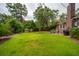 Spacious backyard with lush green lawn, mature trees, and inviting patio area at 614 Beauregard St, Charleston, SC 29412