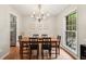Bright dining room features hardwood floors, chandelier, and view of the outdoor greenery through a large window at 614 Beauregard St, Charleston, SC 29412