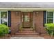 Close-up view of the brick front porch with decorative plants leading to the charming front door of the home at 614 Beauregard St, Charleston, SC 29412