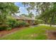 A well-maintained brick home with lush landscaping, mature trees, and a manicured lawn creates a welcoming curb appeal at 614 Beauregard St, Charleston, SC 29412