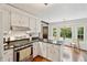 Stylish kitchen with white cabinets, stainless steel appliances, and black countertops with breakfast nook at 614 Beauregard St, Charleston, SC 29412