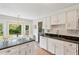 This kitchen features white cabinets, black countertops, subway tile backsplash and a window breakfast nook at 614 Beauregard St, Charleston, SC 29412