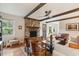 Open-concept living room with exposed beams, hardwood floors, brick fireplace, and lots of natural light at 614 Beauregard St, Charleston, SC 29412
