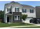 Charming two-story home with a combination of stone and siding exterior and manicured front yard at 677 Redbud Ln, Summerville, SC 29486