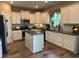 Well-lit kitchen with stainless steel appliances, granite countertops, white cabinets, and hardwood floors at 677 Redbud Ln, Summerville, SC 29486