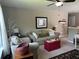 Cozy living room featuring comfortable seating, a red storage chest, and neutral decor, plus a ceiling fan overhead at 677 Redbud Ln, Summerville, SC 29486