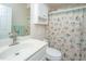 Bright bathroom featuring a white vanity, sink, and toilet complemented by a seashell-themed shower curtain at 69 King Charles Cir, Summerville, SC 29485