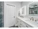 This bathroom features an illuminated mirror, double sinks, and white cabinetry with black hardware at 69 King Charles Cir, Summerville, SC 29485