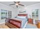 Spacious main bedroom features a ceiling fan, two windows, a dark wood bed frame, and an area rug at 69 King Charles Cir, Summerville, SC 29485