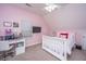 Pink bedroom featuring a desk, a white bed frame with white comforter, and a ceiling fan with lights at 69 King Charles Cir, Summerville, SC 29485