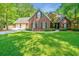 Charming two-story brick home with a well-manicured lawn, mature trees and a three-car garage at 69 King Charles Cir, Summerville, SC 29485