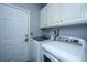 Convenient laundry room with white washer and dryer, complemented by overhead cabinets for storage at 69 King Charles Cir, Summerville, SC 29485