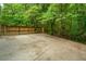 Large concrete parking area with a sturdy wooden fence providing privacy at 69 King Charles Cir, Summerville, SC 29485
