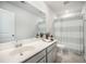 Well-lit bathroom with a neutral countertop, soft gray cabinets, and stylish shower curtain, offering a serene space at 705 Squire Pope Rd, Summerville, SC 29486