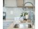 Modern kitchen sink with stainless steel faucet, white countertop, and tile backsplash at 705 Squire Pope Rd, Summerville, SC 29486