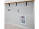 A functional laundry room with wooden shelving and connections for a washer and dryer at 743 Redbud Ln, Summerville, SC 29486