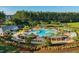 Aerial shot showcasing the community pool area with sun loungers, pergolas, mature trees, and a playground at 743 Redbud Ln, Summerville, SC 29486