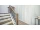 Elegant staircase featuring wood steps, a decorative metal railing, and white paneled walls at 743 Redbud Ln, Summerville, SC 29486