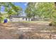 Lush backyard with mature trees and partial fencing, offering privacy and space at 7674 Chippendale Rd, North Charleston, SC 29420