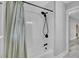 Bathroom interior featuring a shower with a white tiled wall, black shower head, and shower curtain at 7674 Chippendale Rd, North Charleston, SC 29420