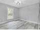 Bright bedroom featuring an empty space with luxury vinyl plank flooring and a large window at 7674 Chippendale Rd, North Charleston, SC 29420