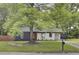 Charming home featuring a mix of modern design, mature tree, and landscaped front yard at 7674 Chippendale Rd, North Charleston, SC 29420